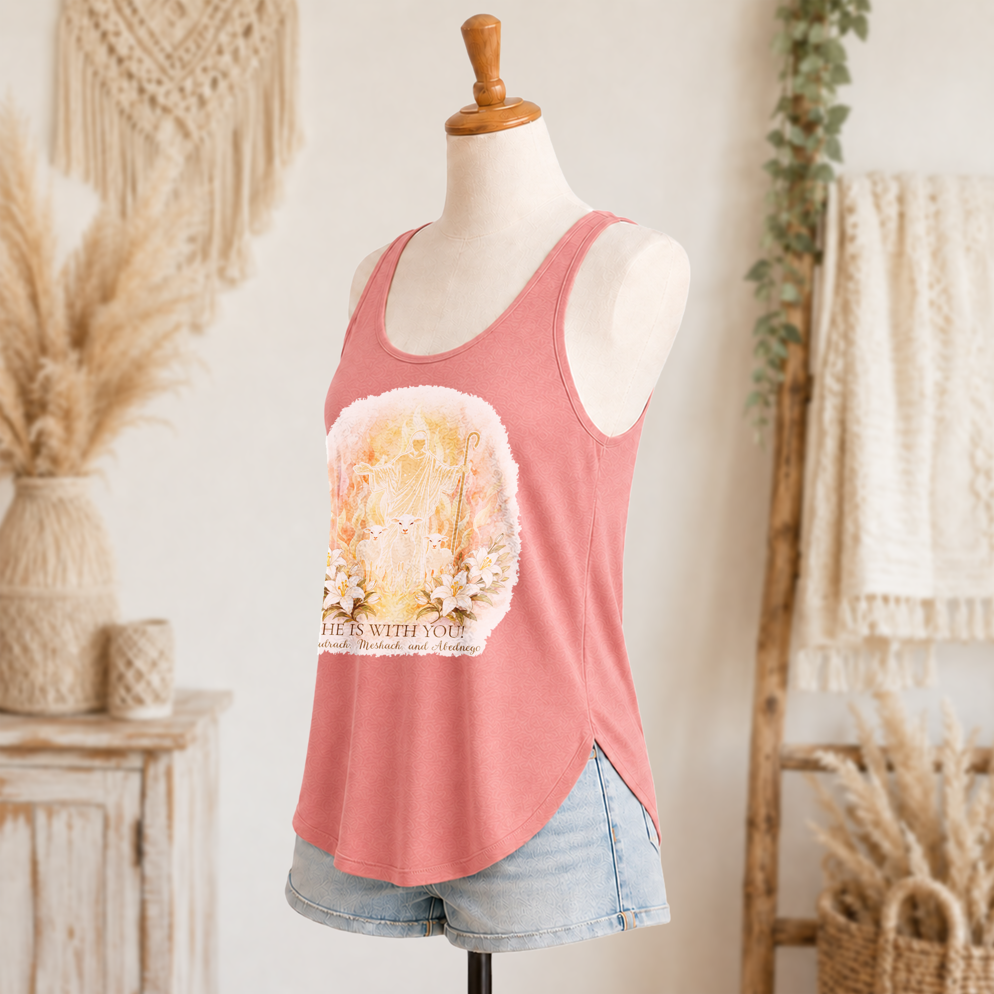 He is with You women’s festival tank side view in desert pink with front Christian artwork and denim shorts