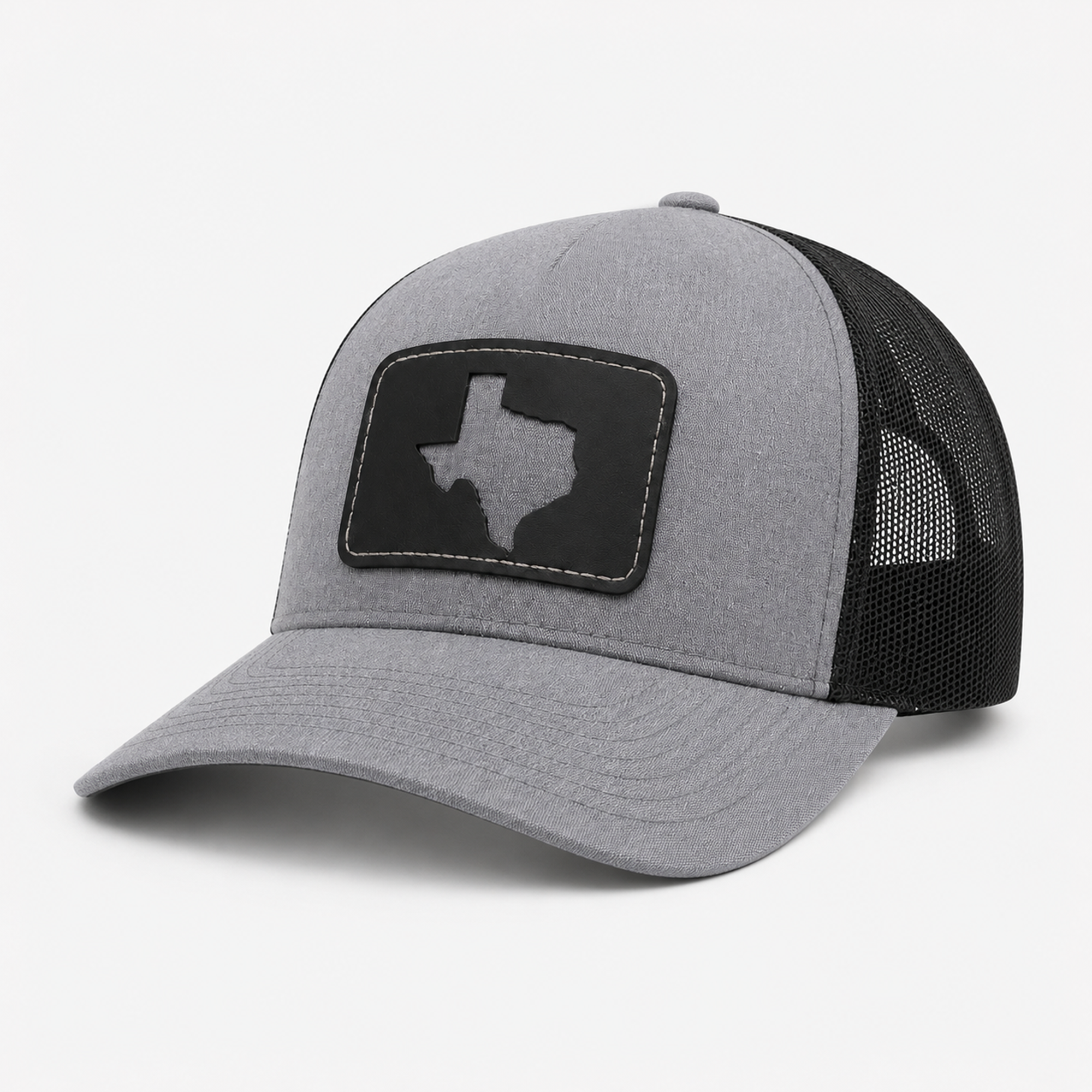 Front side angle of the Texas Cutout Patch Trucker Hat with gray bill, black mesh back, and black Texas cutout patch